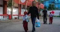 Ayah mengantar anak ke sekolah pada hari pertama tahun ajaran baru