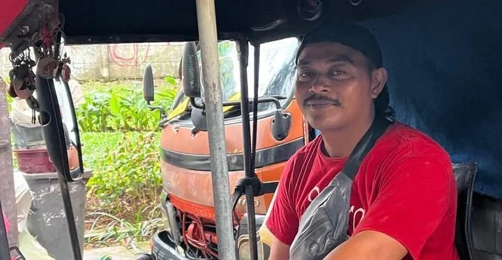 Jenal Abidin saat sedang bekerja mengangkut sampah di Jakarta